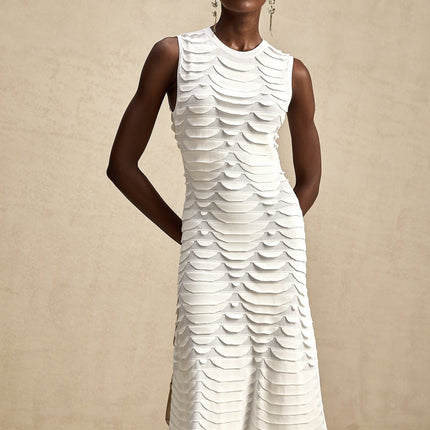 A woman wearing a midi length dress with a snake pattern design and godet inserts for a flared silhouette