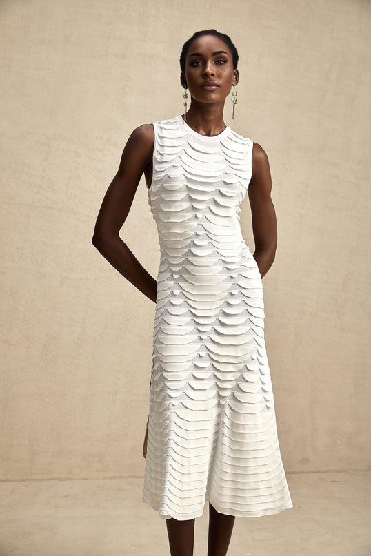 A woman wearing a midi length dress with a snake pattern design and godet inserts for a flared silhouette