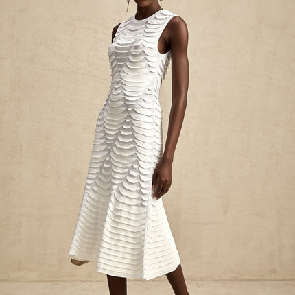 A woman wearing a midi length dress with a snake pattern print and godet flared skirt