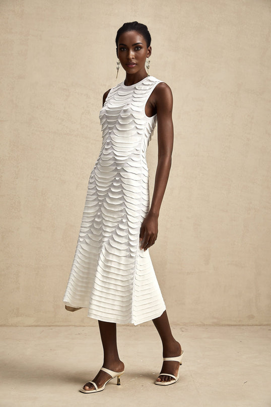 A woman wearing a midi length dress with a snake pattern print and godet flared skirt