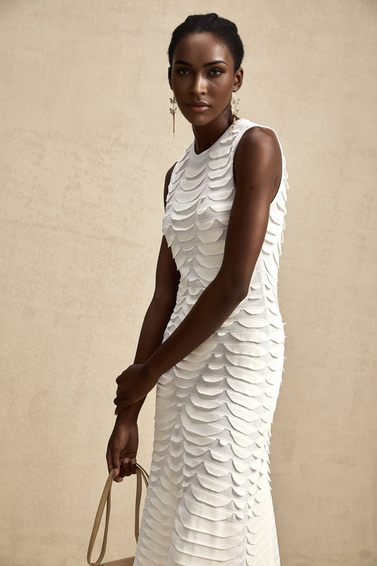 A woman wearing a midi length dress with a snake pattern print and godet skirt design