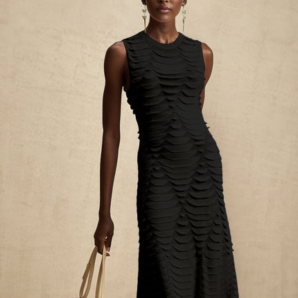 A woman wearing a midi length dress with a snake skin pattern and godet inserts for a flared silhouette