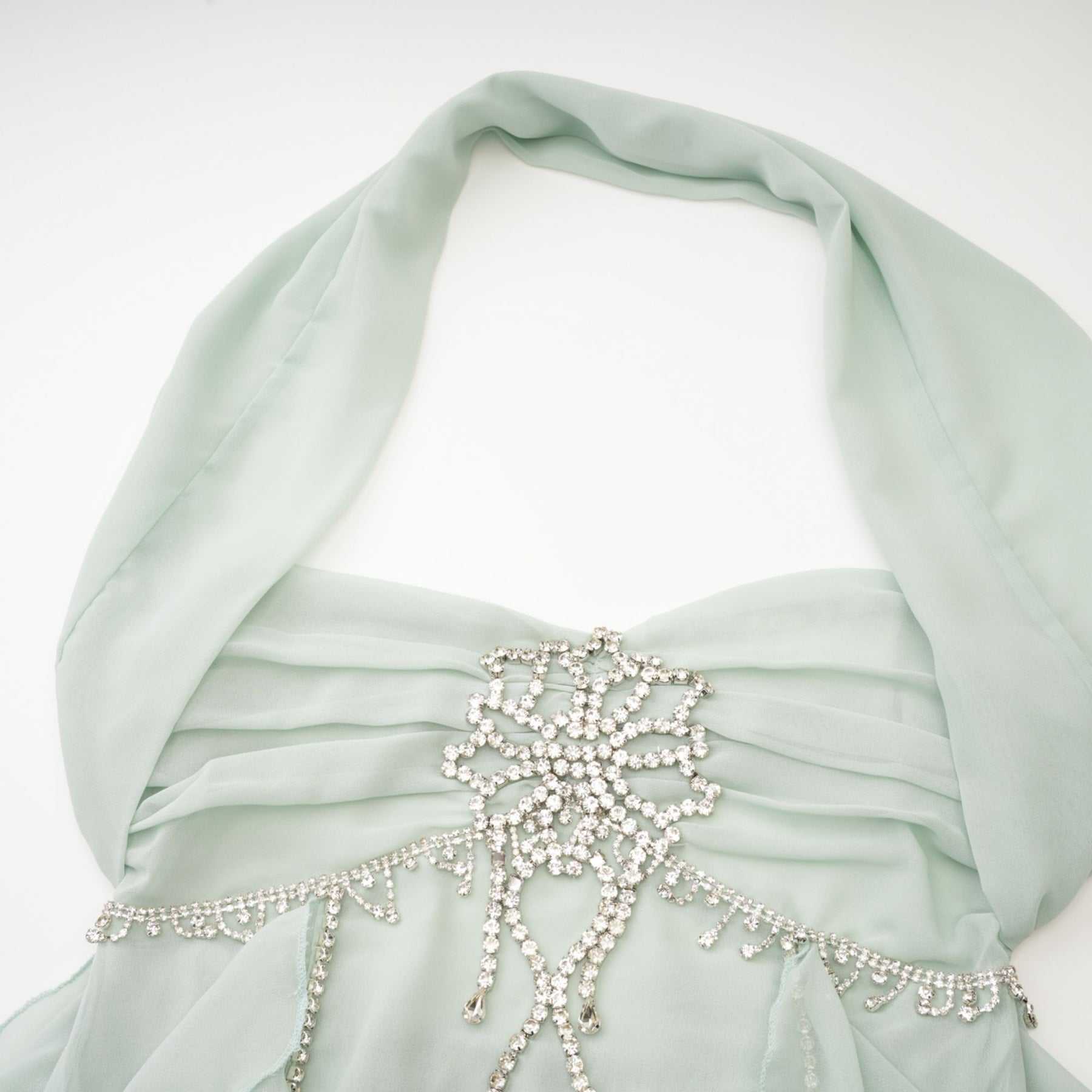 A woman wearing a midi length dress with ruffled details and embellishments Dress has a flowy silhouette and appears to be in a light color The model is shown standing in a relaxed pose