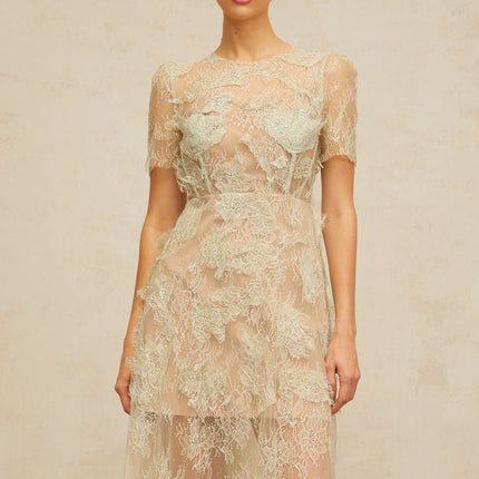 A woman wearing a mintgreen midi dress with floral lace pattern standing in a relaxed pose