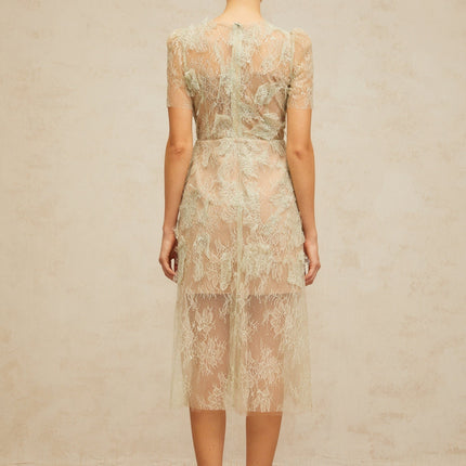 A woman wearing a mintgreen midi dress with floral lace pattern standing in a relaxed pose