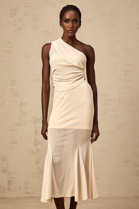 A woman wearing a neutralcolored matching set consisting of a ruched stretch top and skirt named Gwenaelle The outfit has a formfitting design with gathered fabric details