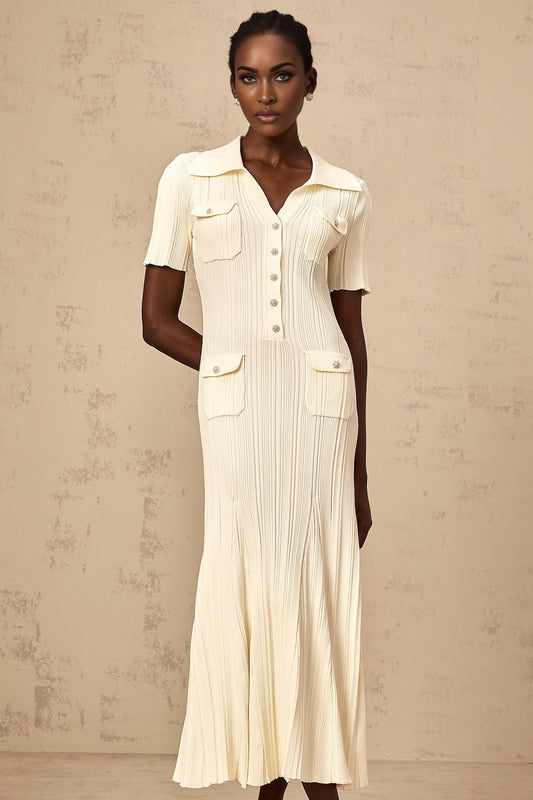 A woman wearing a neutralcolored ribbed knit midi dress with long sleeves standing against a plain background