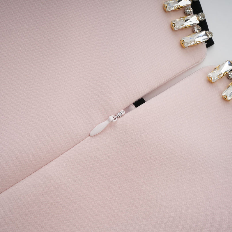A woman wearing a pink crystal colorblocked midi dress with a sleek design featuring contrasting color panels