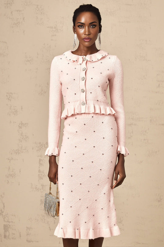 A woman wearing a pink knitted cardigan and matching skirt with an argyle check pattern The set is called Julia and features a coordinated top and bottom in a classic style