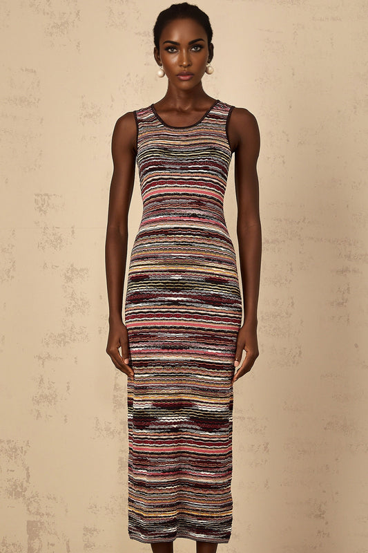 A woman wearing a purple striped crochet knit midi dress with long sleeves standing against a plain background