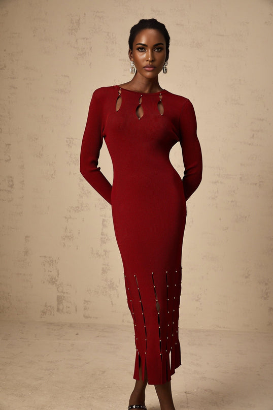 A woman wearing a red knit midi dress with long sleeves beaded details and cutout accents