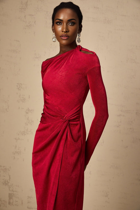 A woman wearing a red midi dress with a high slit and gathered fabric details