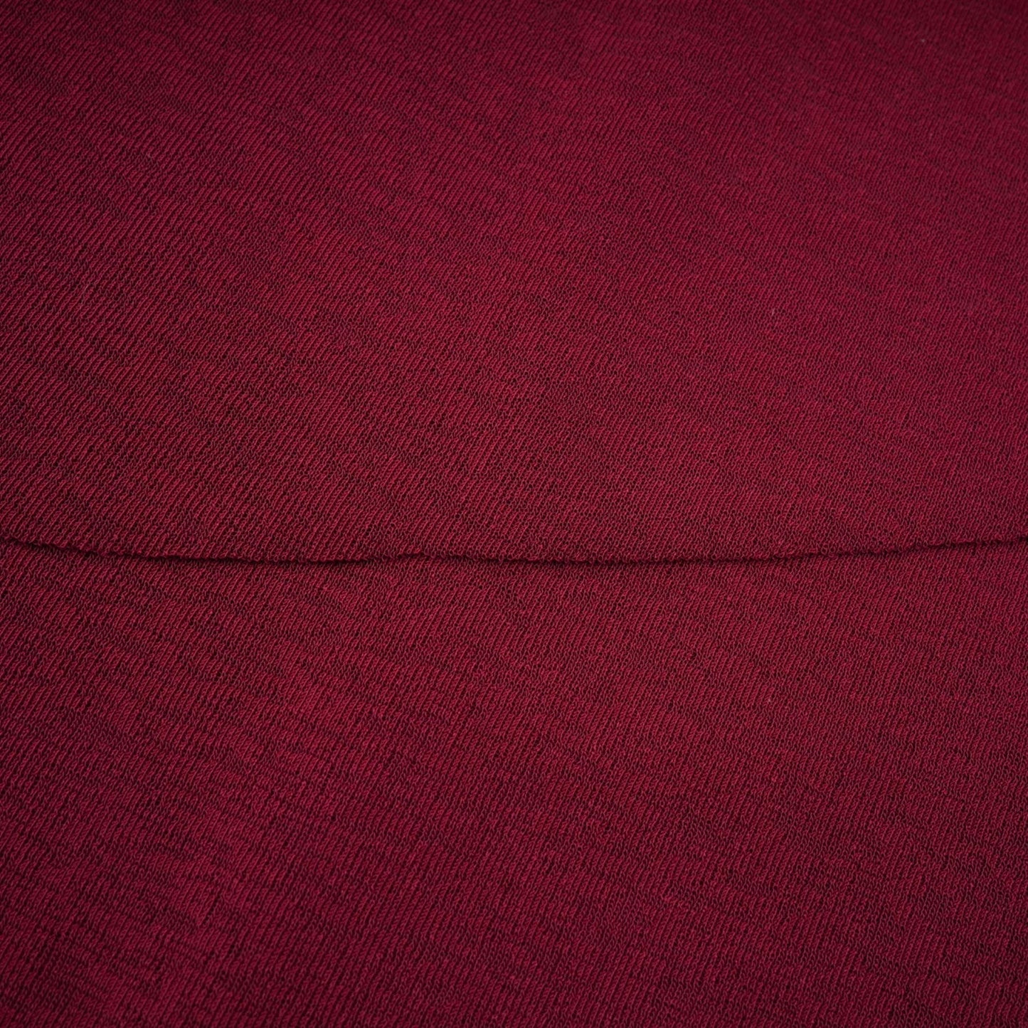 A woman wearing a red midi dress with ruched detailing and a flap design on the front