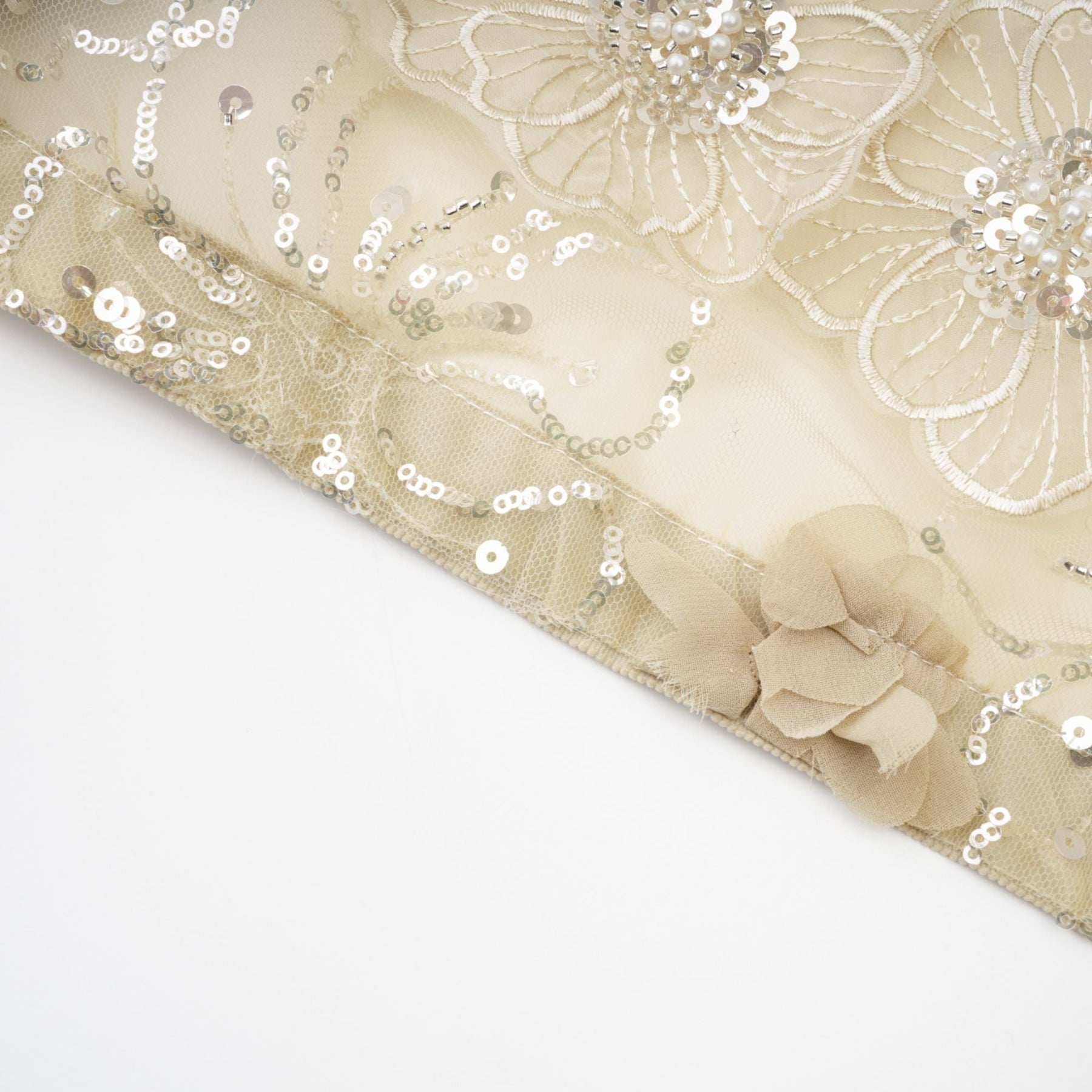 A woman wearing a sheer floral jacket with beaded embellishments and delicate organza fabric in a light luxurious style