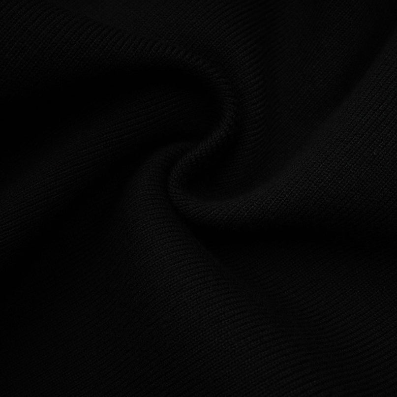 A woman wearing a short wool dress with colorblocked panels in contrasting shades and a ribbed knit texture The dress has long sleeves and a fitted silhouette ending above the knees