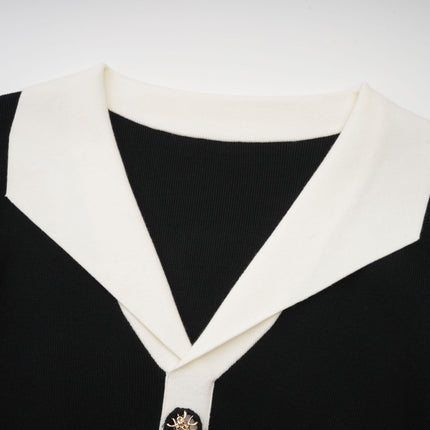 A woman wearing a short wool dress with colorblocked sections and ribbed knit texture featuring long sleeves and a fitted silhouette