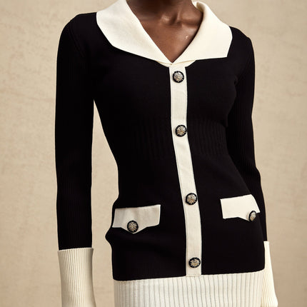 A woman wearing a short wool dress with colorblocked sections and ribbed knit texture in contrasting colors