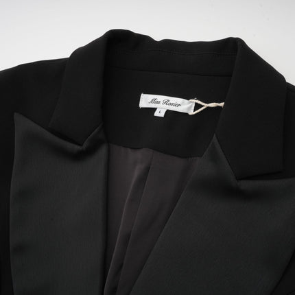 A woman wearing a sleek black blazer dress with a singlebreasted design and a tailored silhouette