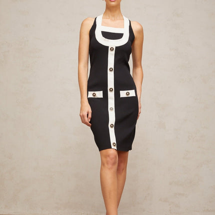 A woman wearing a sleeveless knit mini dress with a halter neckline The dress features color blocking with contrasting sections The model stands in a relaxed pose showing the fitted silhouette of the dress