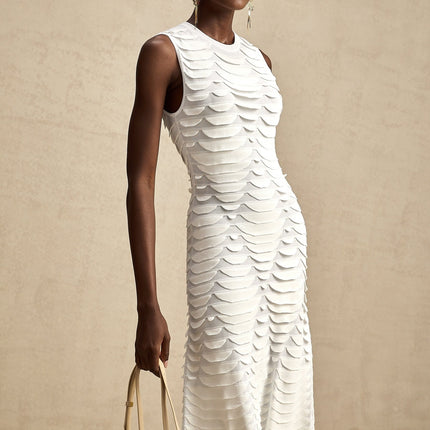A woman wearing a snakepattern midi dress with godet inserts flaring out from the knees creating a flowing silhouette the dress has long sleeves and a high neckline