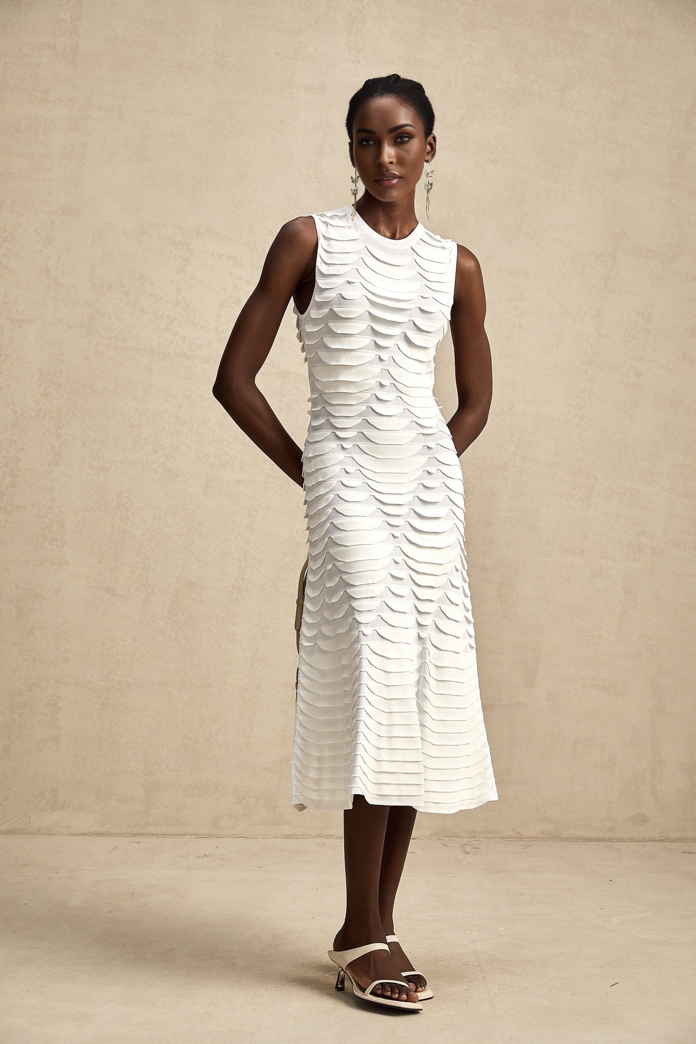 A woman wearing a snakeskin patterned midi dress with a flared godet skirt silhouette