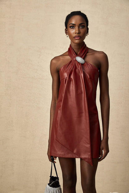 A woman wearing a vibrant red halterneck mini dress made of sheepskin with a fitted silhouette and bare shoulders