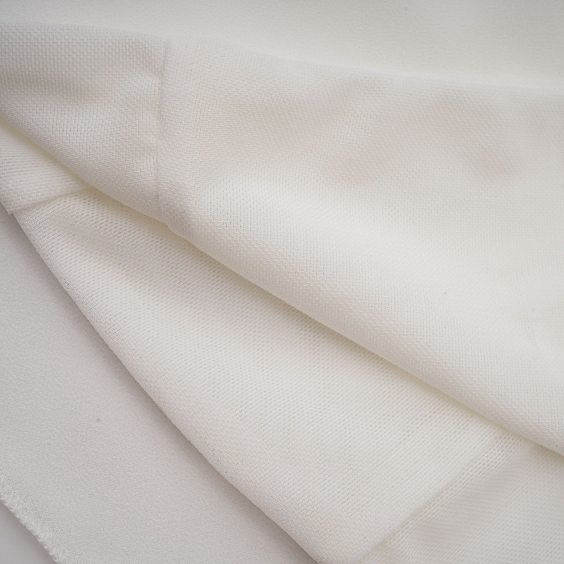 A woman wearing a white chiffon blouse named Jeanne with flowing sleeves and a relaxed fit
