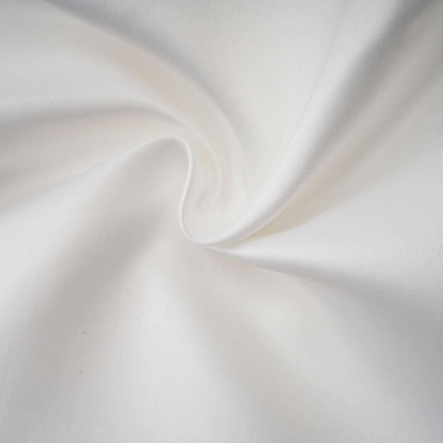 A woman wearing a white halterneck mini dress with ruffles standing against a plain background