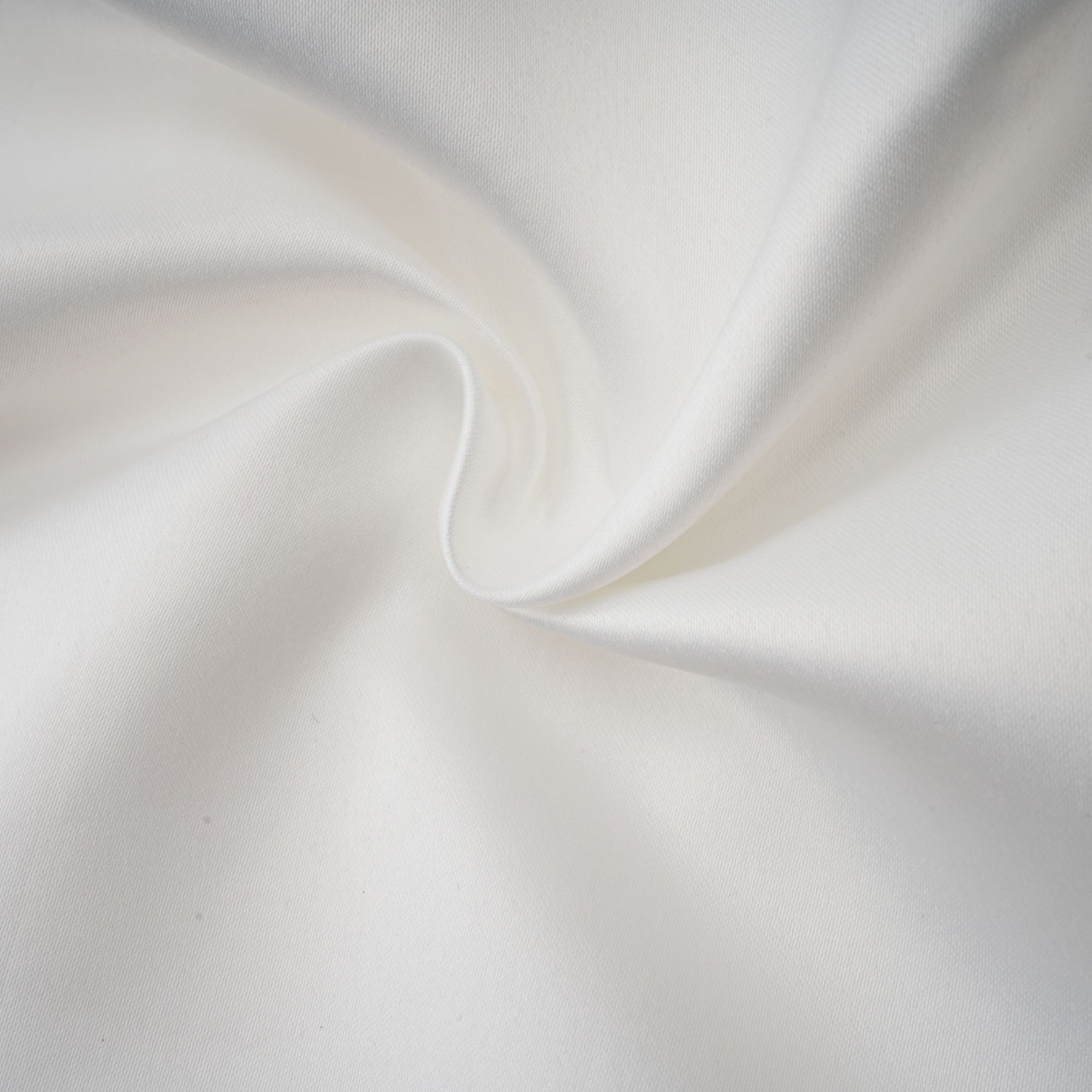 A woman wearing a white halterneck mini dress with ruffles standing against a plain background