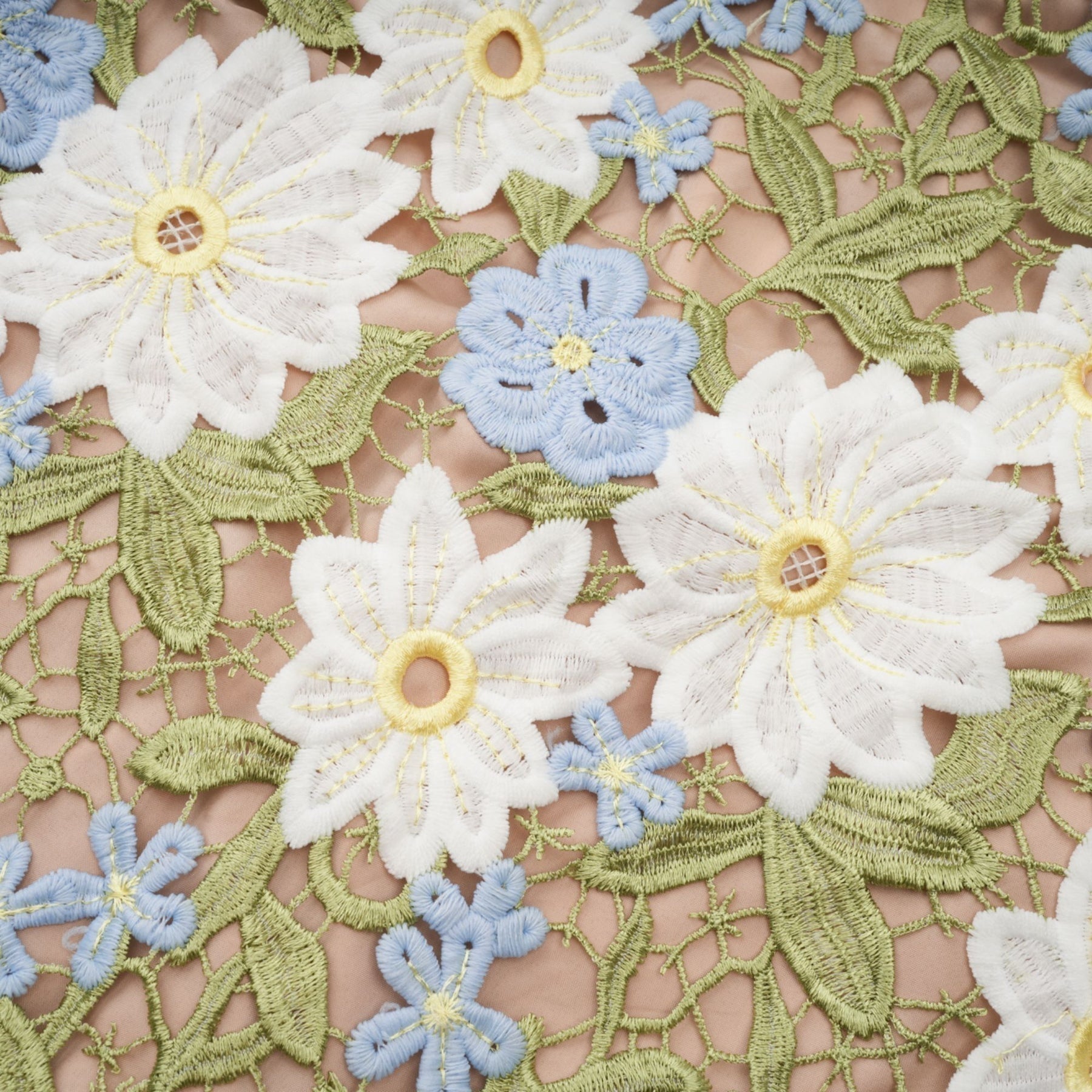 A woman wearing a white midi dress with floral embroidery and cutout details standing in a relaxed pose
