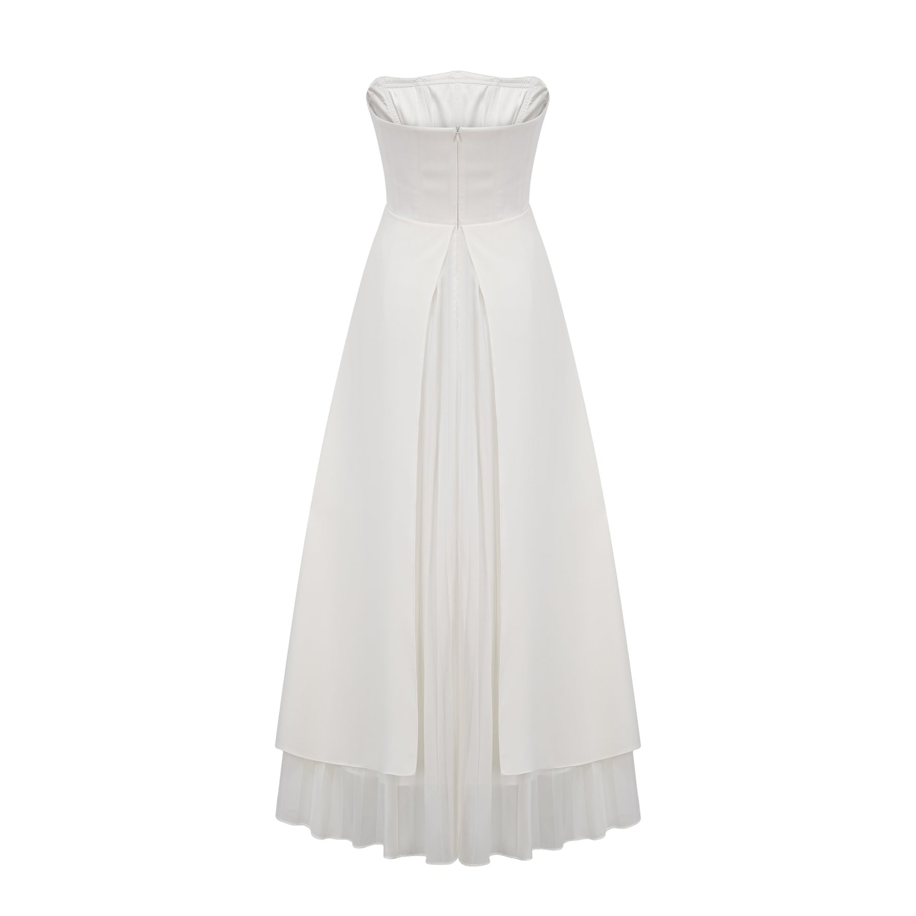 A woman wearing a white pleated offshoulder maxi dress with a flowing skirt standing against a plain background