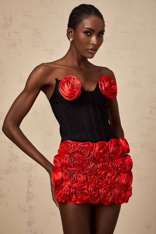 A womans matching set featuring a red top and skirt adorned with rose appliques named Heloise