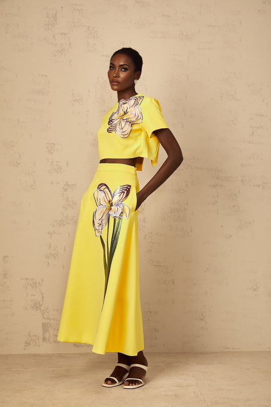A womens yellow twopiece outfit featuring sequin floral embroidery on both the top and bottom pieces of the matching set