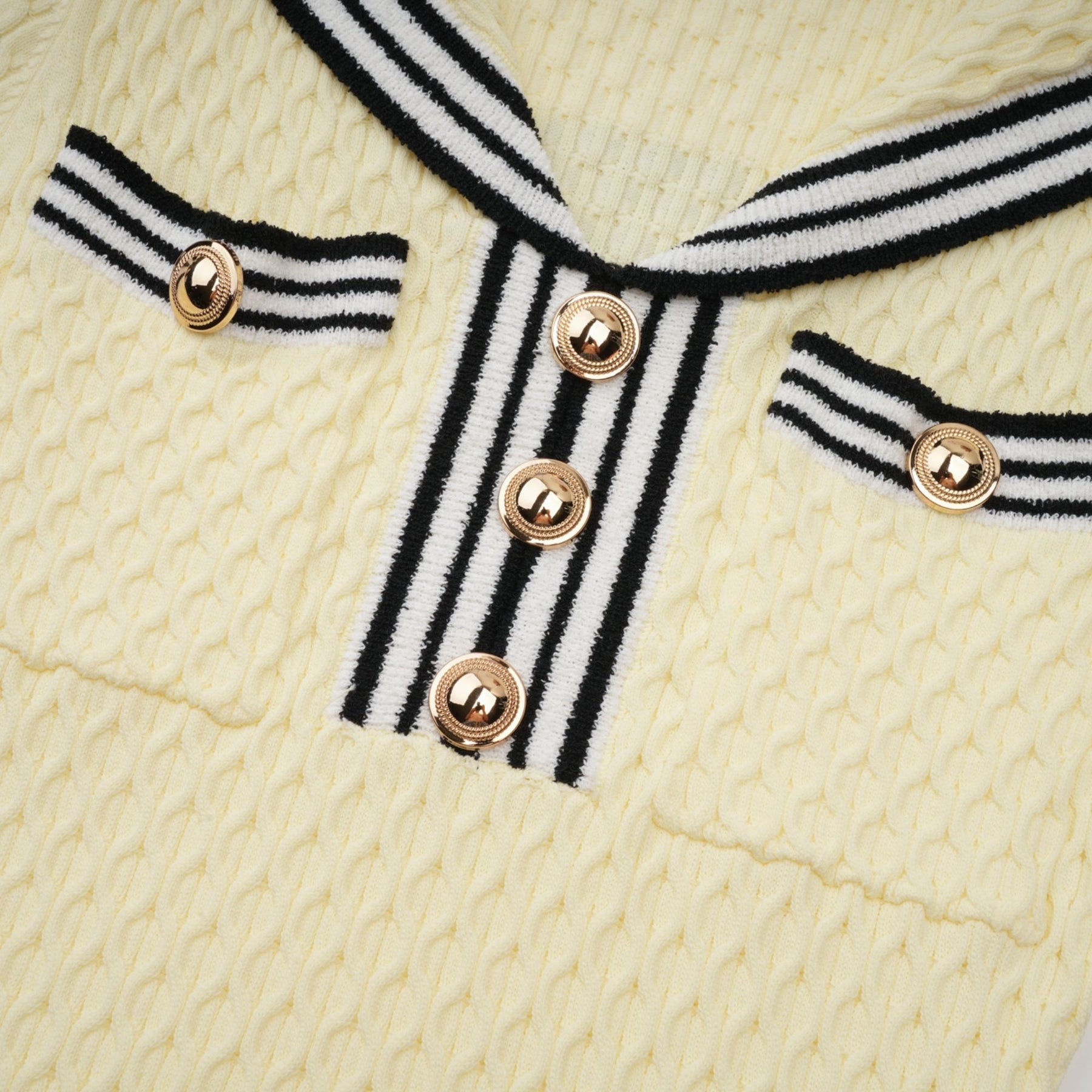 A yellow knitted dress with a sailor collar and Madeleine style featuring a fitted silhouette and short sleeves