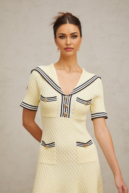 A yellow knitted dress with a sailor collar design featuring a Madeleine style