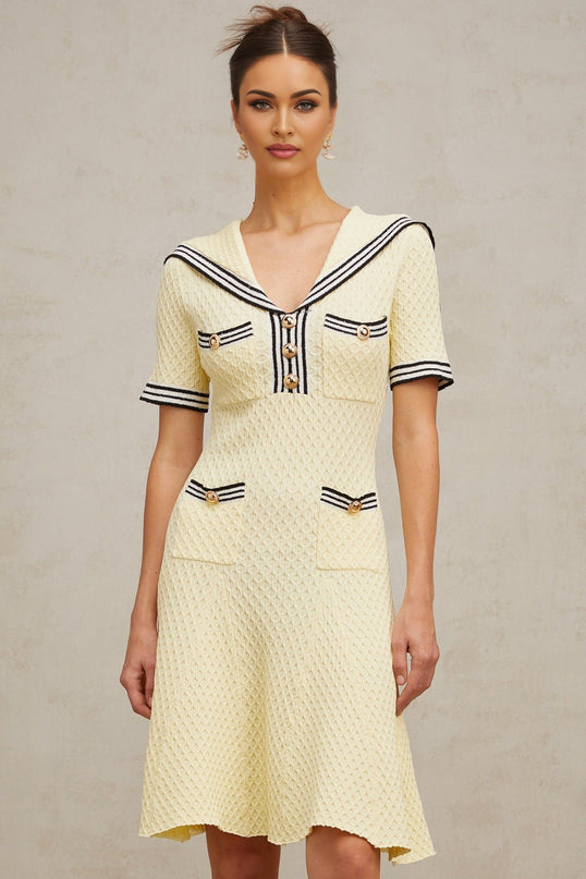 A yellow knitted dress with a sailor collar featuring a Madeleine style design