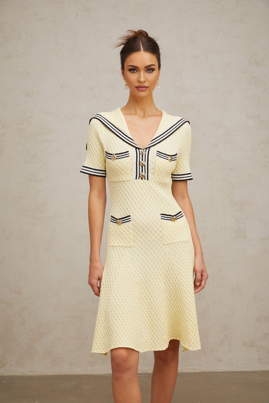 A yellow knitted dress with a sailor collar featuring a Madeleine style design