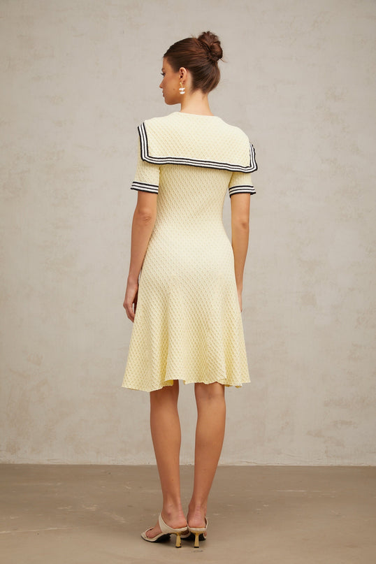 A yellow knitted dress with a sailor collar style featuring a Madeleine design