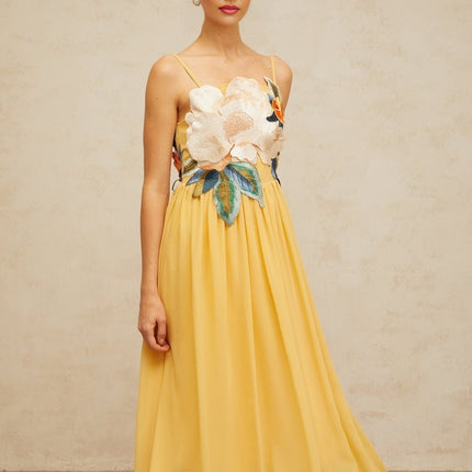 A yellow maxi dress with floral embroidery and shirred detailing named Josette