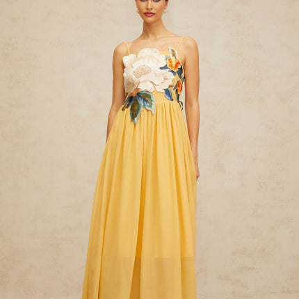 A yellow maxi dress with floral embroidery and shirred detailing named Josette