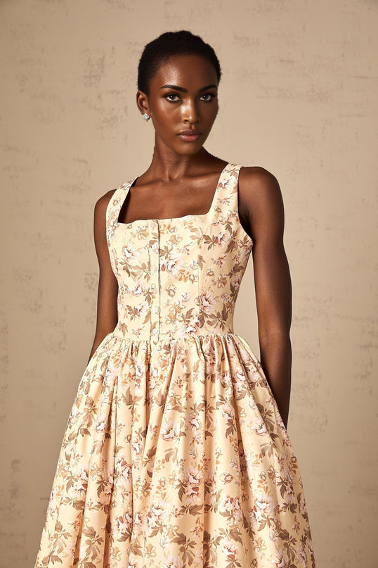 A yellow midi dress with a floral print pattern and button detailing