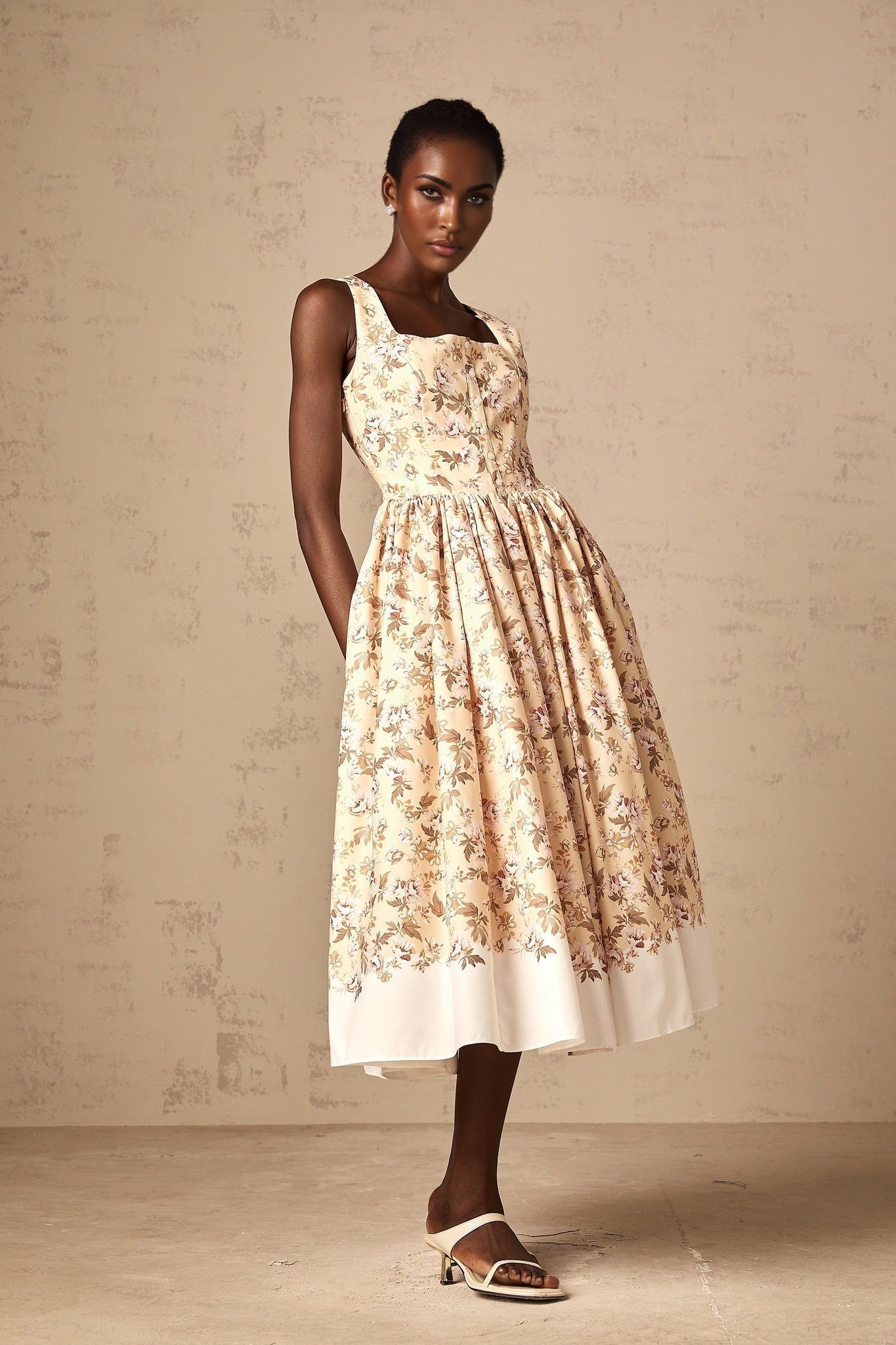A yellow midi dress with a floral print pattern and button details