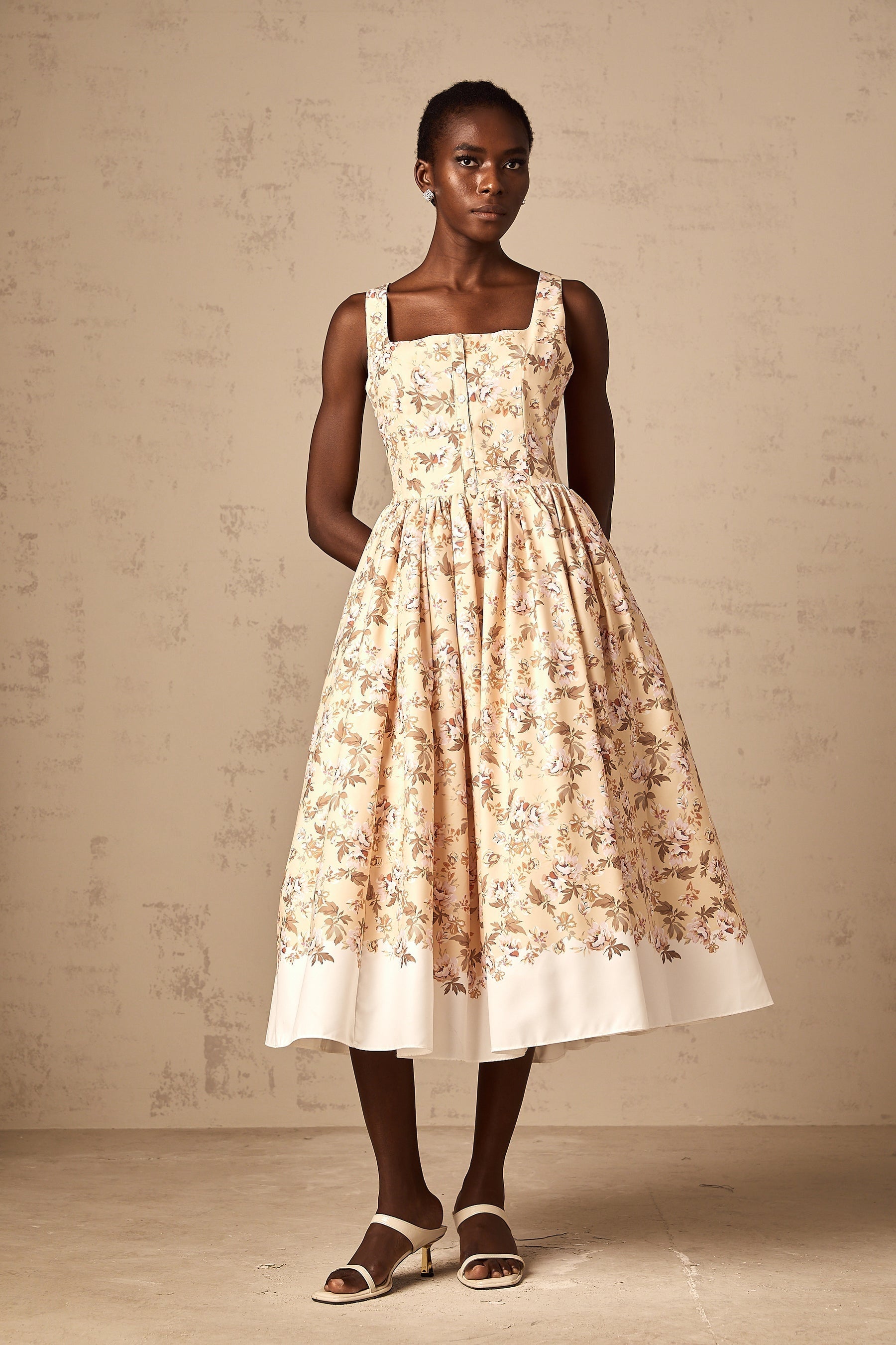 A yellow midi dress with a floral print pattern and button details