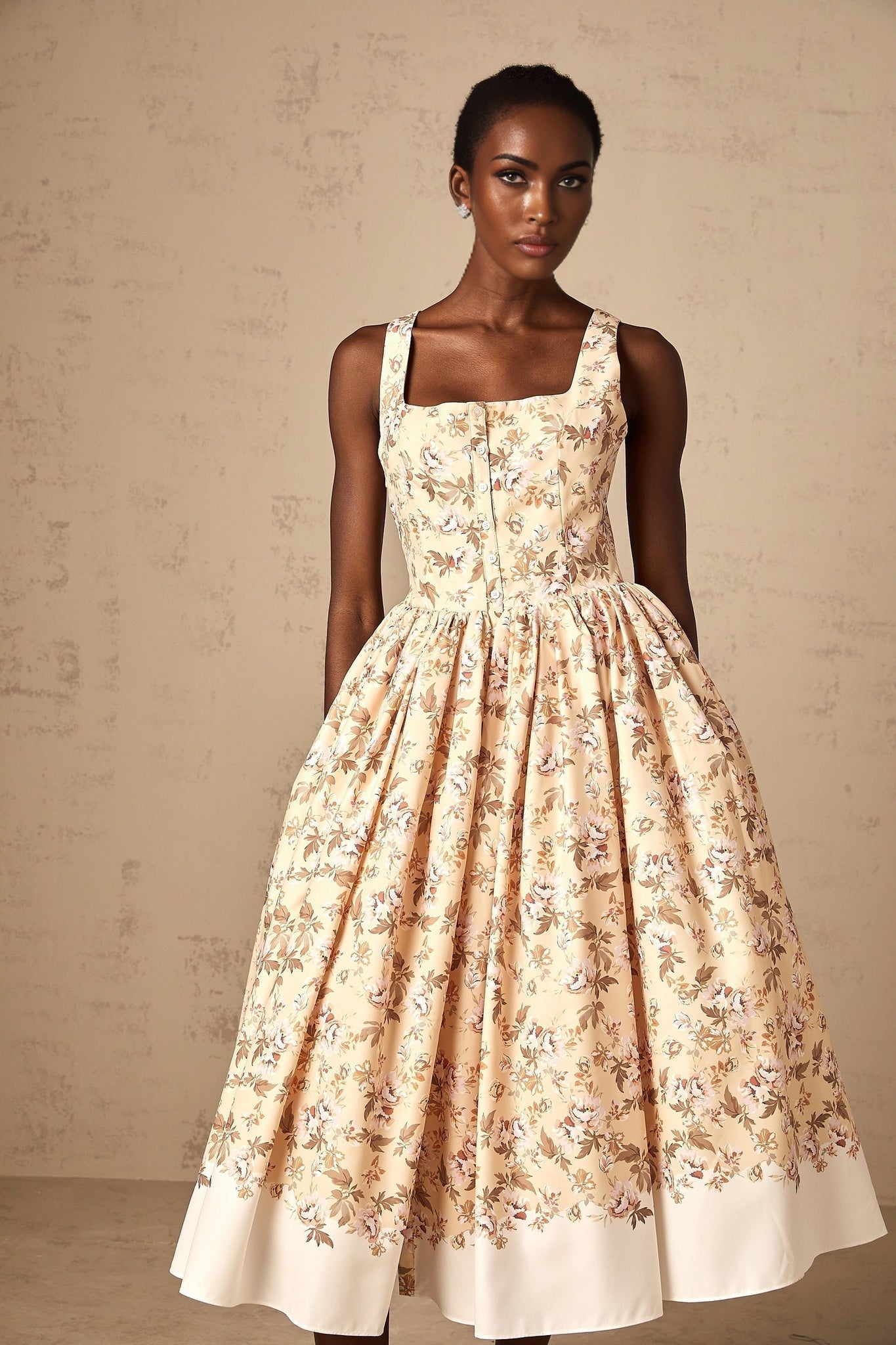 A yellow midi dress with a floral print pattern and buttons down the front