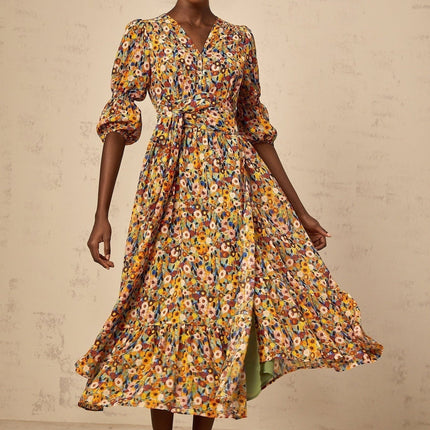 A yellow midi dress with a floral print pattern and V neckline called Eliane