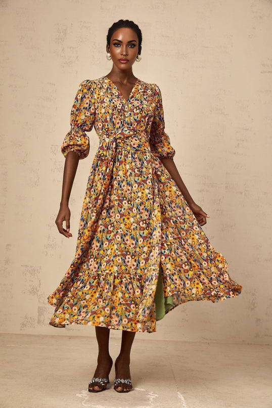 A yellow midi dress with a floral print pattern and V neckline called Eliane
