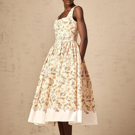 A yellow midi dress with a floral print pattern featuring buttons and a feminine silhouette