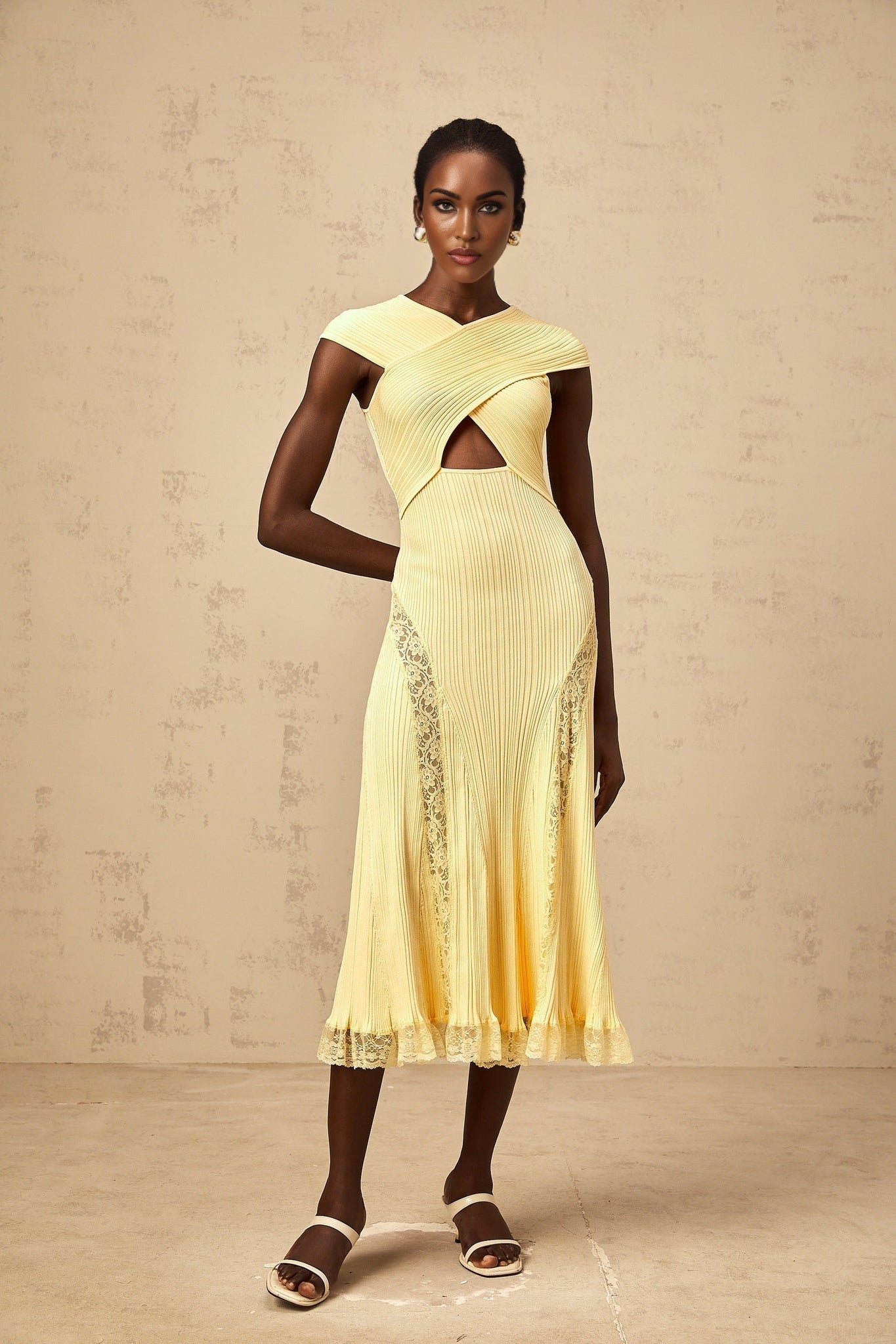 A yellow midi dress with a ribbed knit texture featuring lace panels and a formfitting silhouette