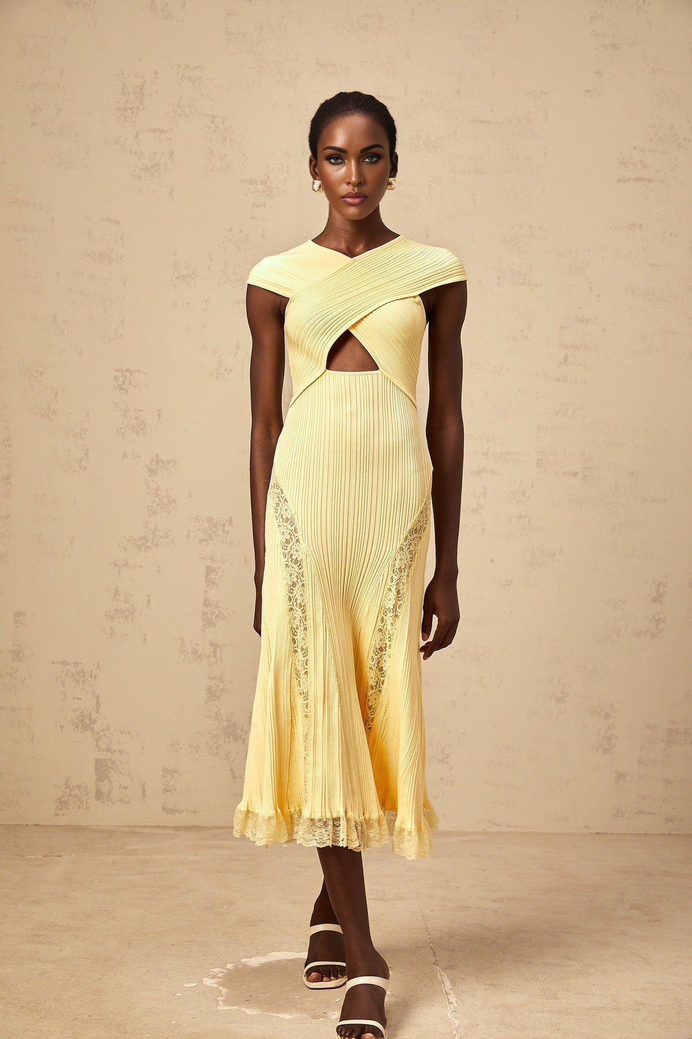 A yellow midi dress with ribbed knit fabric and lace panel details featuring a fitted silhouette and sleeveless design