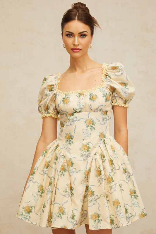 A yellow mini dress with a floral print pattern and shirred detailing named Tiphaine